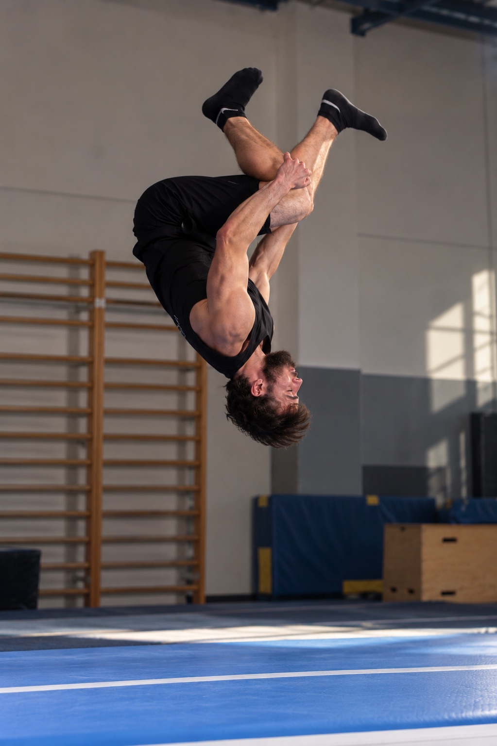 Mężczyzna wykonujący salto podczas treningu akrobatyki dla dorosłych Acrojoy